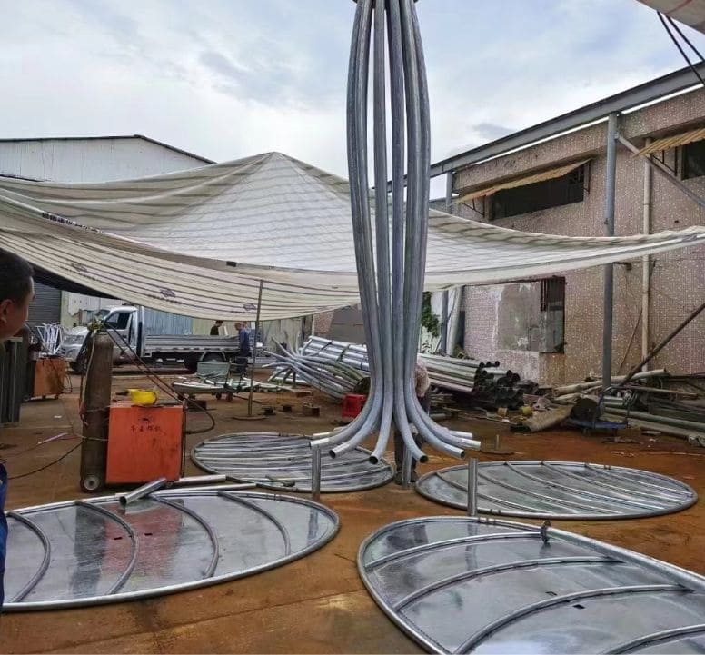 Workers welding components of a solar powered tree